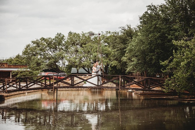 "Reflection Of Bride & Groom From Curved Bridge"